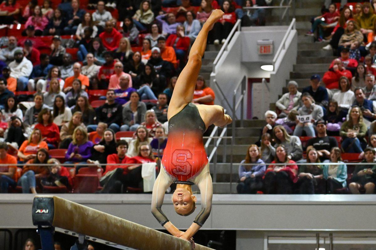 Freshman Katie Harper performs a back walkover on the beam during the meet against Clemson in Reynolds Coliseum on Saturday, Feb. 17, 2024. Harper scored a 9.850 on her beam routine. NC State beat Clemson 197.575-196.000.