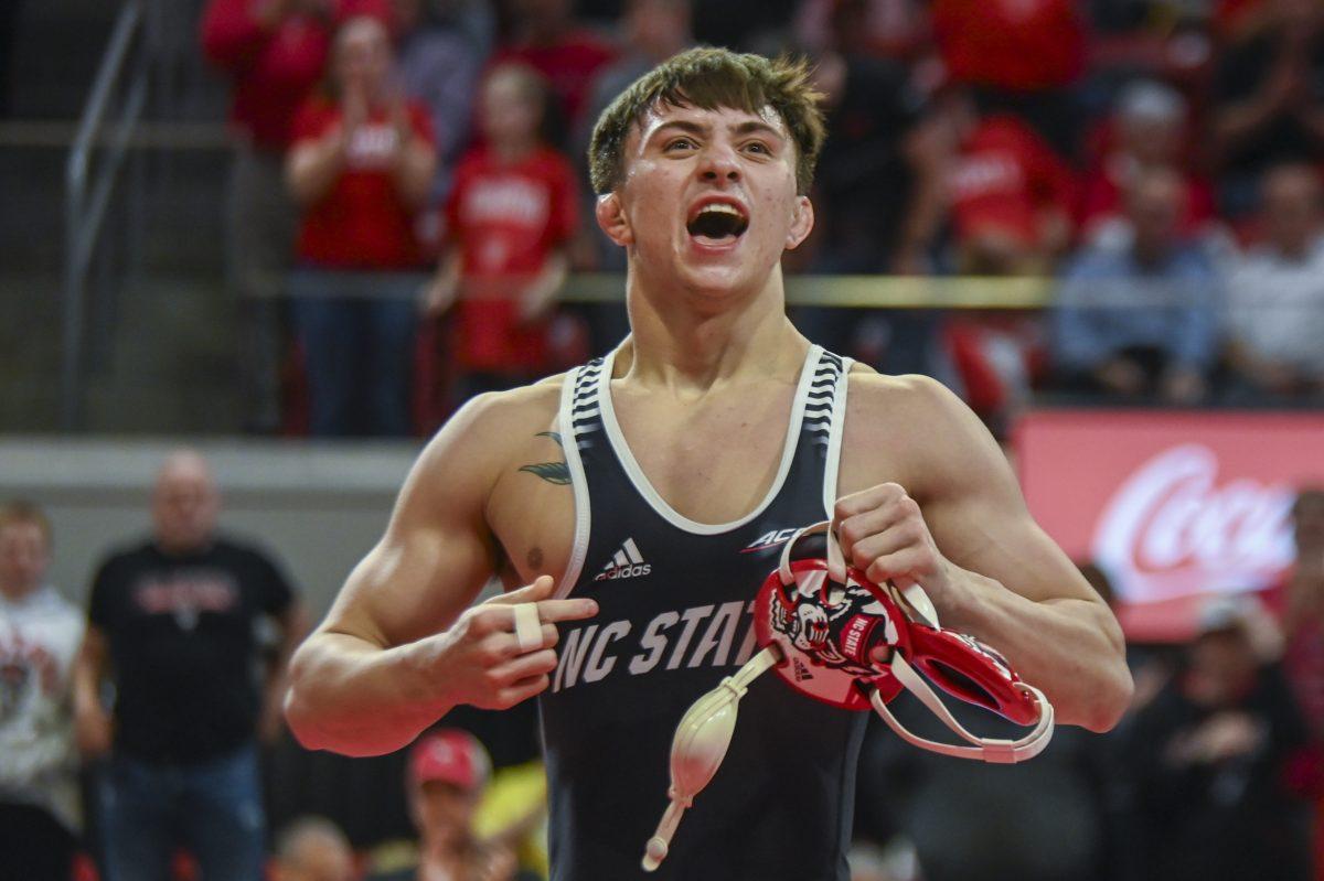 Sophomore Jackson Arrington points to the NC State lettering on his singlet after winning the 149 bout against Cornell during the wrestling match in Reynolds Coliseum on Friday, Feb. 16, 2024. Arrington won by major decision with a score of 12-2. NC State beat Cornell 24-9.