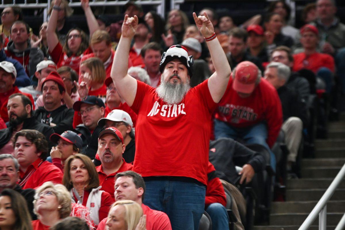 NC State fan Greg Haas sings with the band during the NCAA March Madness round two game against the Oakland University Golden Grizzlies in PPG Paints Arena on Saturday, March 23, 2024. The Wolfpack beat the Golden Grizzlies 79-73 in overtime.
