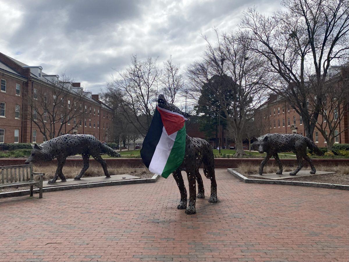 A Palestinian flag hangs from a statue in Wolf Plaza after a protest on Monday, March 4. NC State's Arab Student Organization and Students for Justice in Palestine organized the pro-Palestine protest, which began in Wolf Plaza.