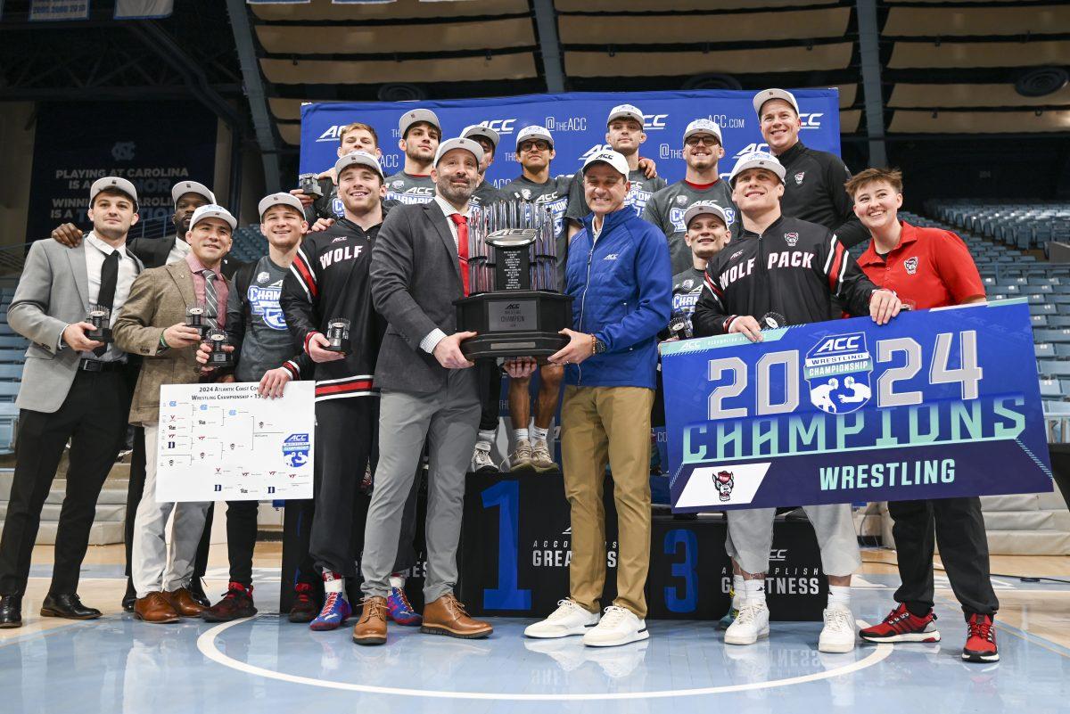 The NC State wrestling team poses with the ACC Championship trophy during the 2024 ACC Wrestling Championship in Carmichael Arena on Sunday, March 10, 2024. NC State won their sixth consecutive ACC Championship.