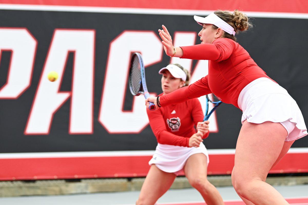 Freshman Gabriella Broadfoot and senior Abigail Rencheli reach to return the ball during the match against Notre Dame at Dail Outdoor Tennis Stadium on Friday, March 1, 2024. Broadfoot and Rencheli won their doubles match 6-1. NC State beat Notre Dame 5-2.