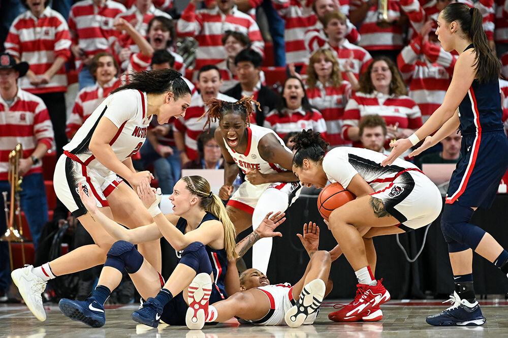 The women's basketball team celebrates junior guard Aziaha James offensive play as UConn redshirt junior guard Paige Bueckers picks up her fourth foul during the game in Reynolds Coliseum on Sunday, Nov. 12, 2023. James scored 14 points and made four rebounds. NC State defeated UConn 92-81.
