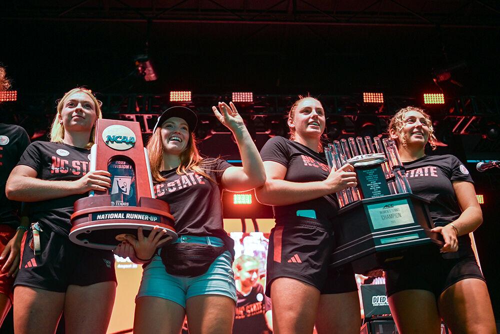 Women's tennis freshman Chloe Henderson, junior Sophie Abrams, junior Amelia Rajecki and junior Abigail Rencheli hold up their ACC and NCAA trophies during the pep rally at Packapalooza at Hillsborough Street on Saturday, Aug. 26, 2023. Packapalooza is a street festival that celebrates the beginning of the new school year. The pep rally showcased student athletes across multiple teams at NC State.