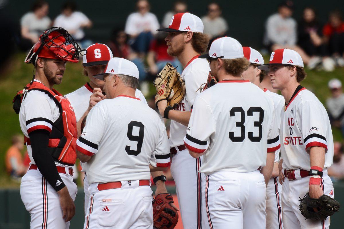 Head coach Elliott Avent discusses strategy with players during a timeout during the game against Duke at Doak Field at Dail Park on Saturday, March 23, 2024. NC State defeated Duke 9-8.