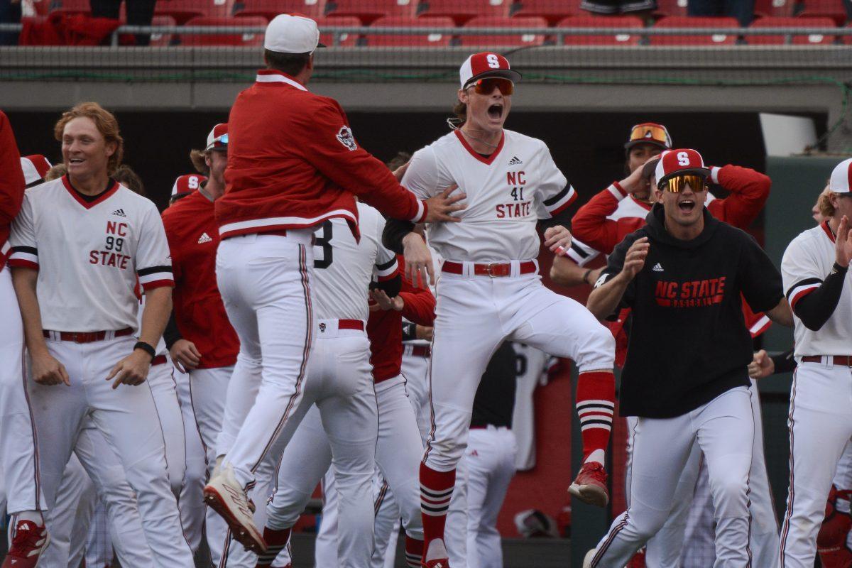 Freshman pitcher Jacob Dudan jumps for joy with teammates after winning the game against Duke at Doak Field at Dail Park on Saturday, March 23, 2024. The Wolfpack defeated the Blue Devils 9-8.