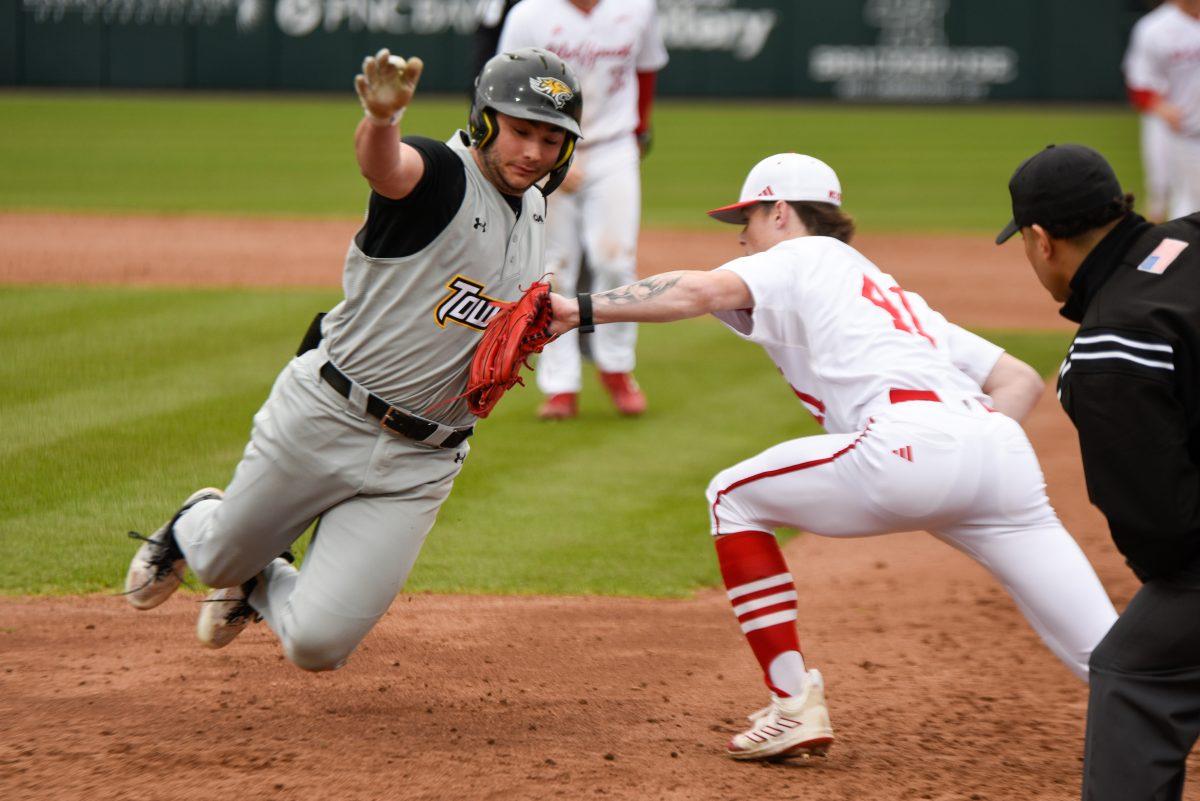 Freshman right-handed pitcher Jacob Dudan tags out an opposing player during the game in Doak Field at Dail Park on Friday, March 1, 2024. The Wolfpack defeated the Tigers 6-5.