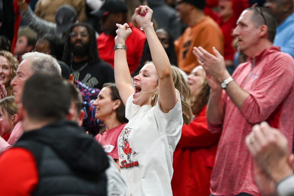 NC State fan Hannah Justus celebrates a win during the NCAA March Madness round two game against the Oakland University Golden Grizzlies in PPG Paints Arena on Saturday, March 23, 2024. The Wolfpack beat the Golden Grizzlies 79-73 in overtime.