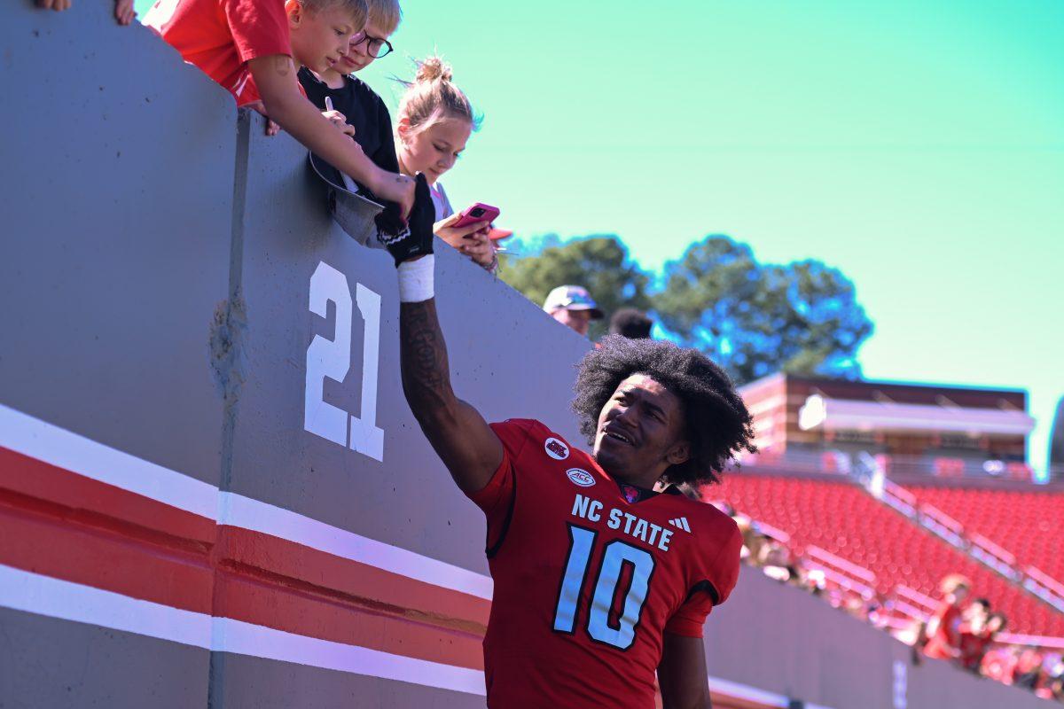 Sophomore wide receiver Kevin Conception high-fives fans during the spring game at Carter-Finley Stadium on Saturday, April 6, 2024. The Red team beat the White team 51-7.