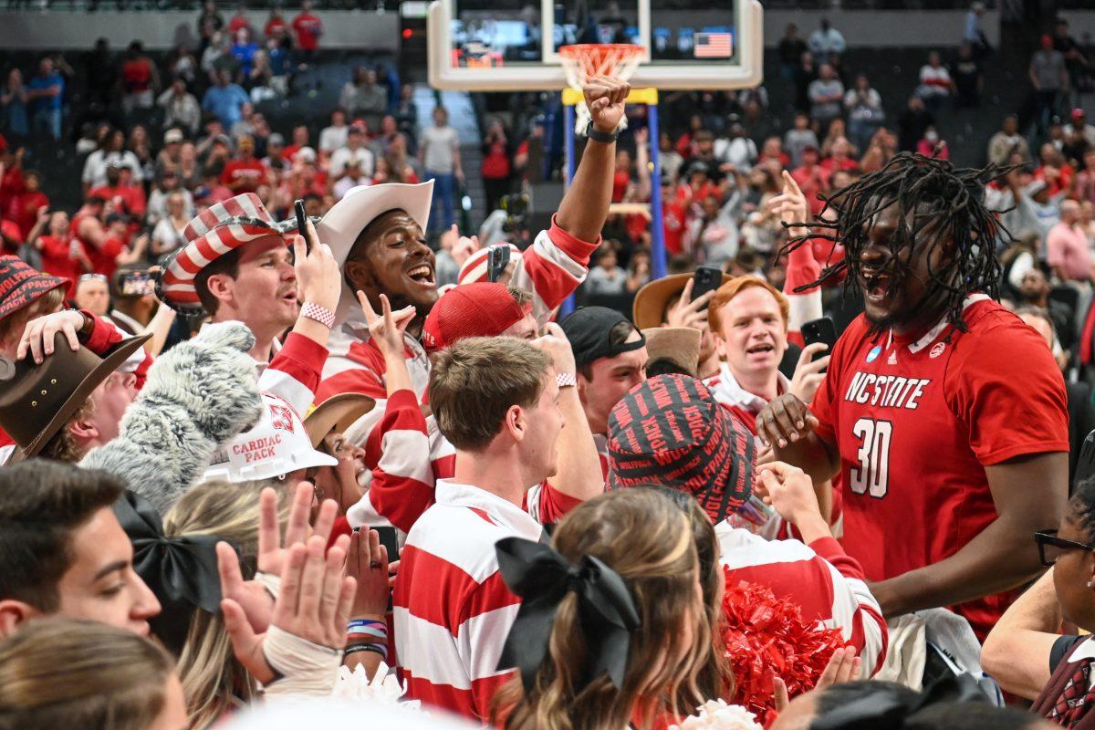 Graduate forward DJ Burns celebrates with the pep band after winning the NCAA Tournament Elite 8 game against Duke at American Airlines Center in Dallas on Sunday, March 31, 2024. Burns led in scoring with 29 points. NC State beat Duke 76-64 to advance to the Final Four.