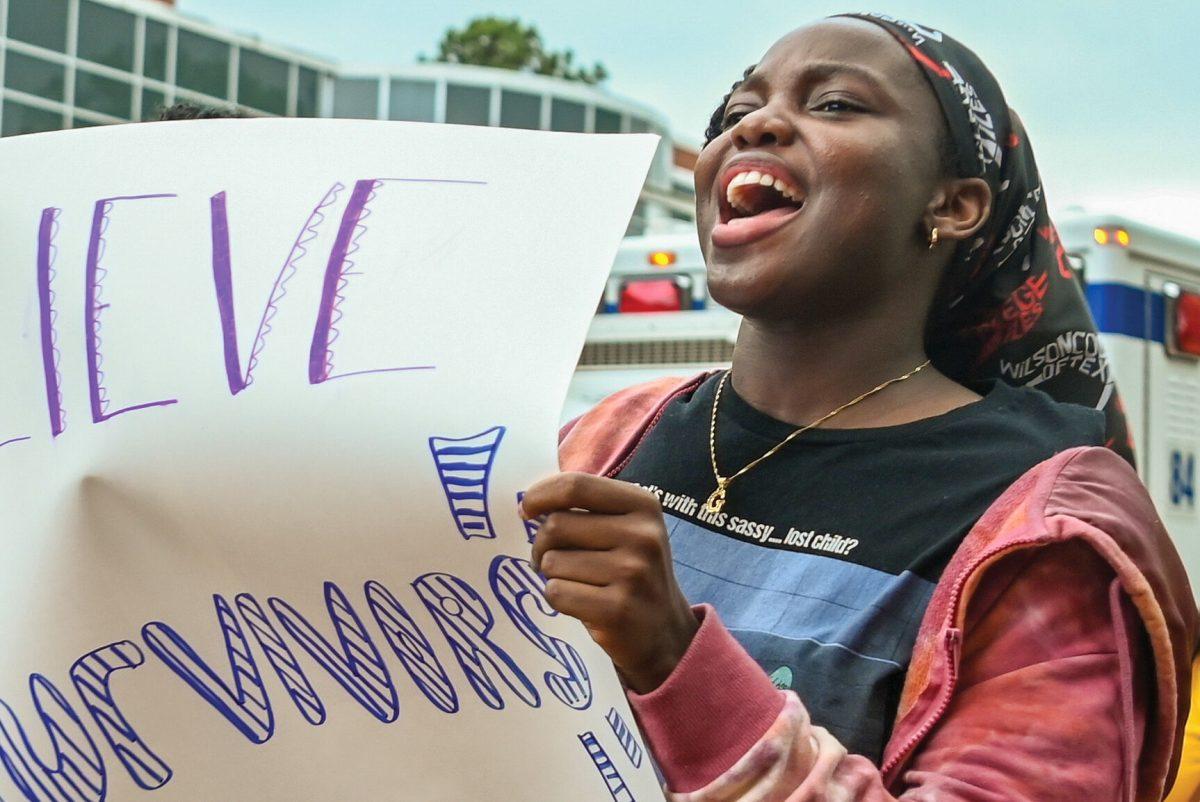 Iremide Adejayan, a third-year studying polymer and color chemistry, chants while holding a sign with a friend during Take Back The Night which marched around Main Campus on Thursday, April 11, 2024. Take Back The Night is an annual event that is held to honor survivors of sexual assault.