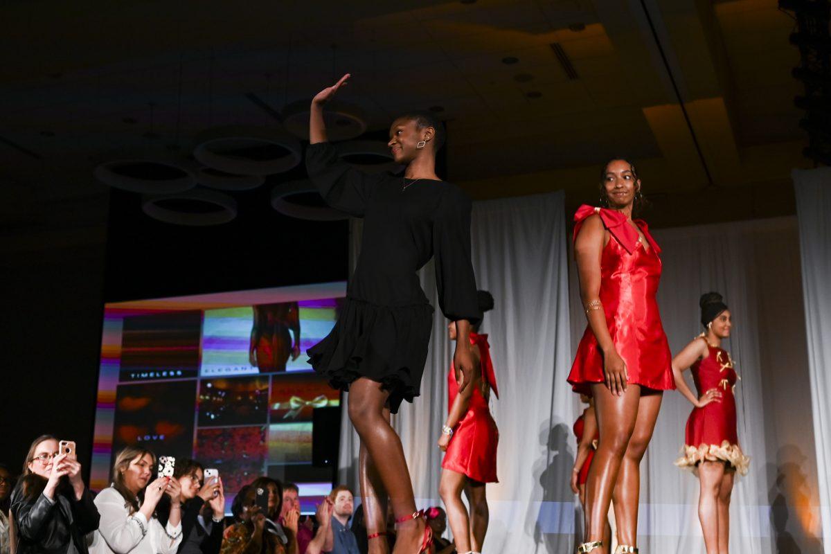 Zion Pittman, a third-year studying fashion and textile management, waves to the audience after displaying her collection, "XOXO," at the 26th Annual Fashion Expose in Tally Student Union on April 8, 2024. Pittman's designs were a part of her very first collection, which she presented in the novice category.
