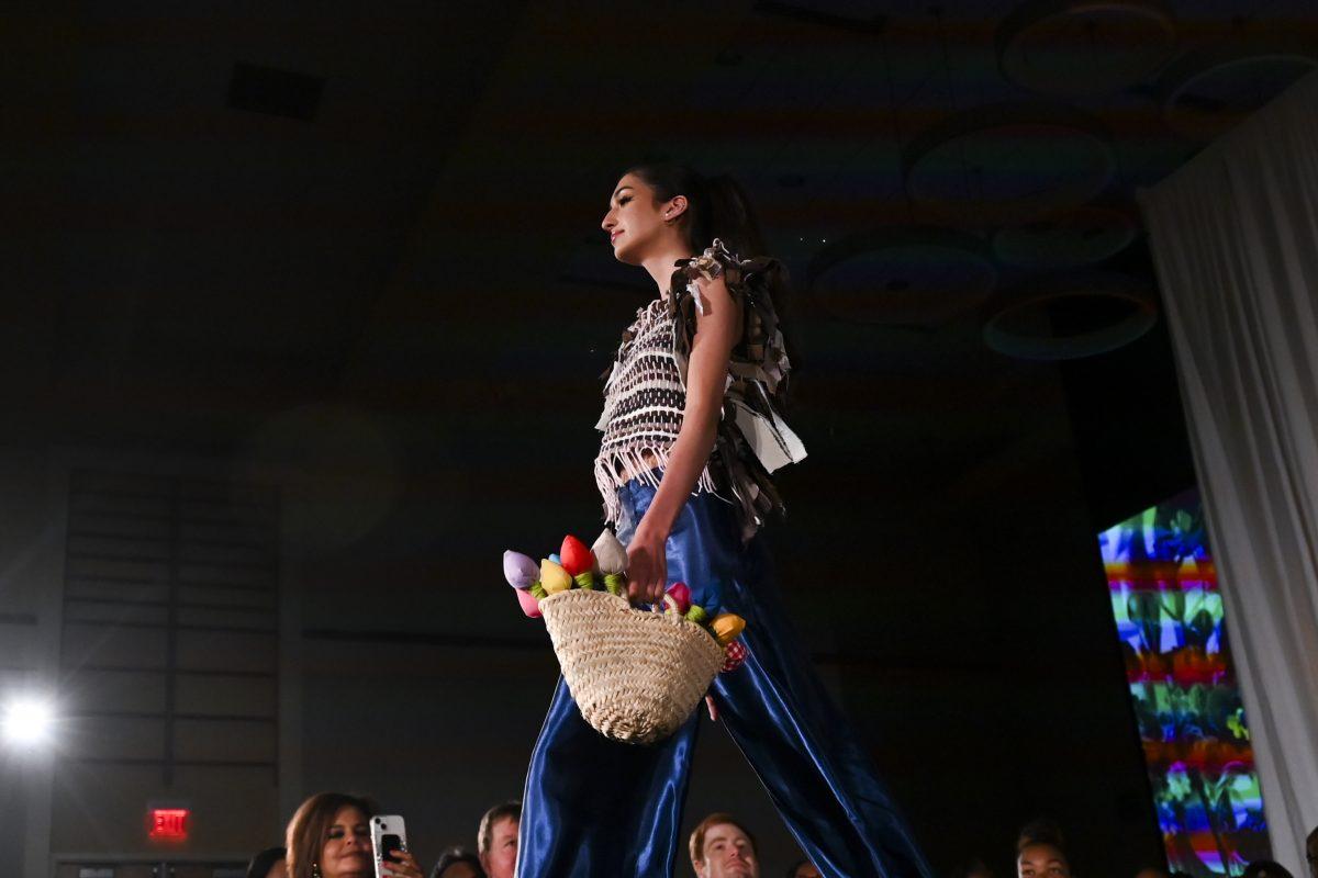 A model carries a basket of flowers down the runway in a design from Jeana Grace Bowker's collection, "SALVAGED," at the 26th Annual Fashion Expose in Tally Student Union on April 8, 2024. The Expose is a part of Pan-Afrikan Week and was hosted by the African American Textile Society.