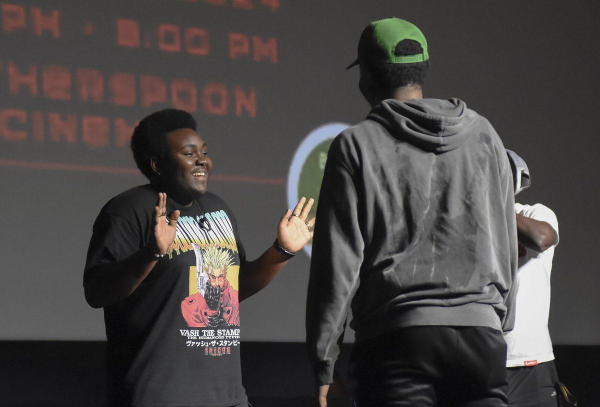 X raises their hands defensively after being accused of cheating at the Packed Out Game Night event in Witherspoon Student Cinema on Wednesday, April 10, 2024. Students lunged to grab a cup before one another once the song ended.