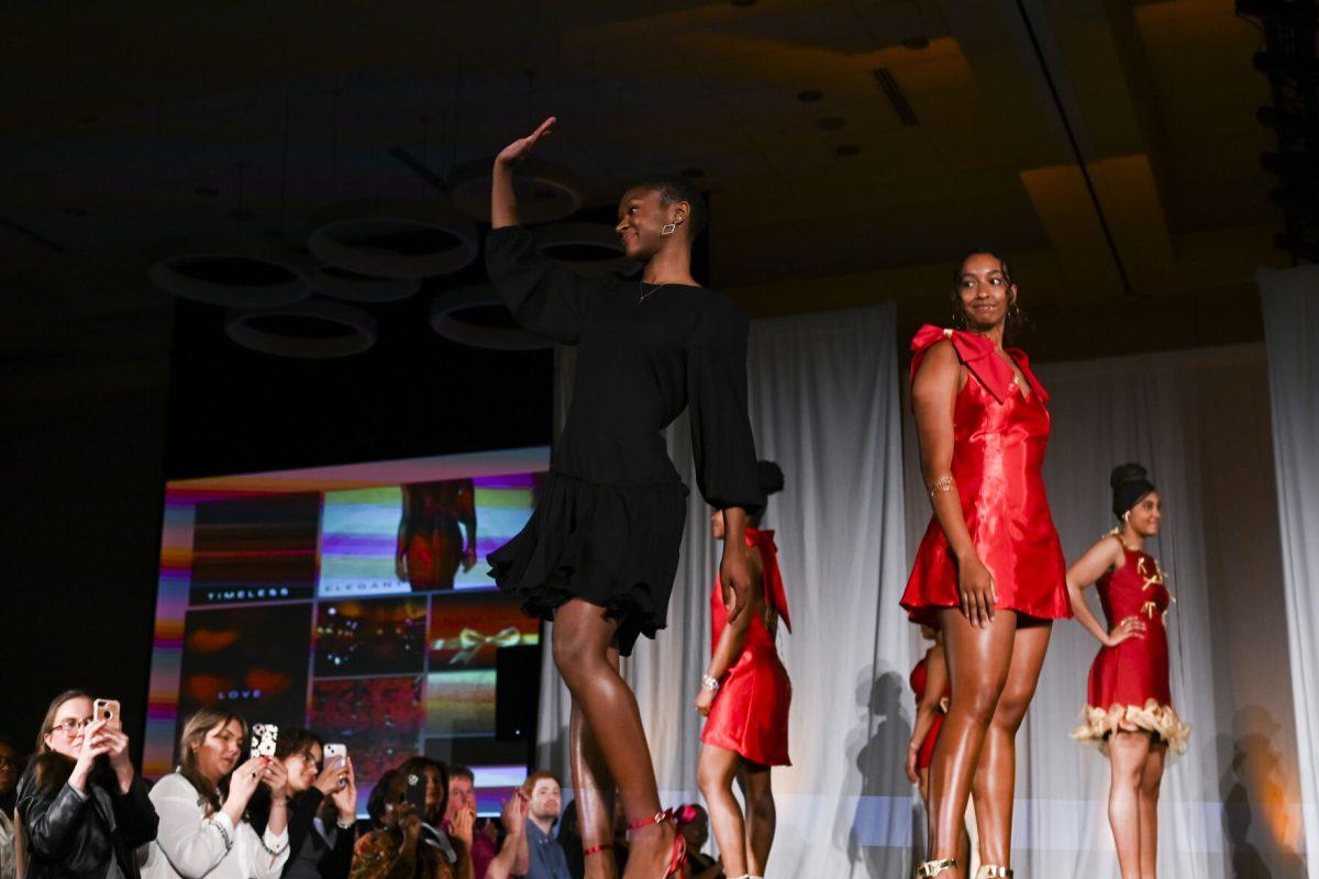 Zion Pittman, a third-year studying fashion and textile management, waves to the audience after displaying her collection, "XOXO," at the 26th Annual Fashion Expose in Tally Student Union on April 8, 2024. Pittman's designs were a part of her very first collection, which she presented in the novice category.