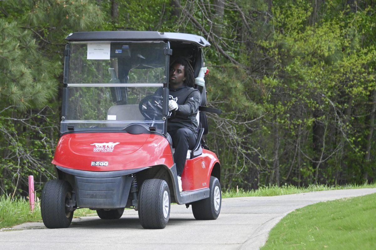Adam Pederson drives the golf cart to the next hole during the Stitch Intercollegiate golf match on Lonnie Poole Golf Course on Friday, April 12, 2024.