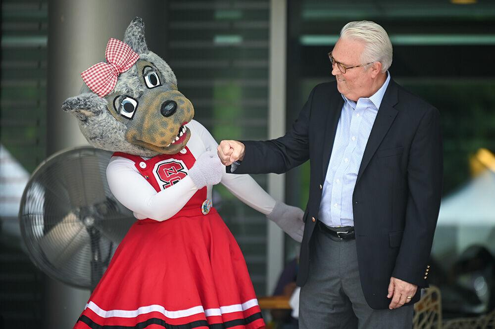 Ms. Wuf and Chancellor Randy Woodson fist bump during PrideFest at Stafford Commons on Tuesday, Oct. 3, 2023. PrideFest is an annual celebration to recognize and honor the LGBTQ+ members of the Wolfpack.