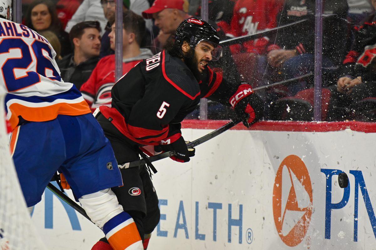 Carolina Hurricanes defenseman Jaylen Chatfield battles a player for the puck during the game against the New York Islanders on Thursday, Nov. 30, 2023. Chatfield had one goal. The Islanders beat the Hurricanes 5-4 in overtime.