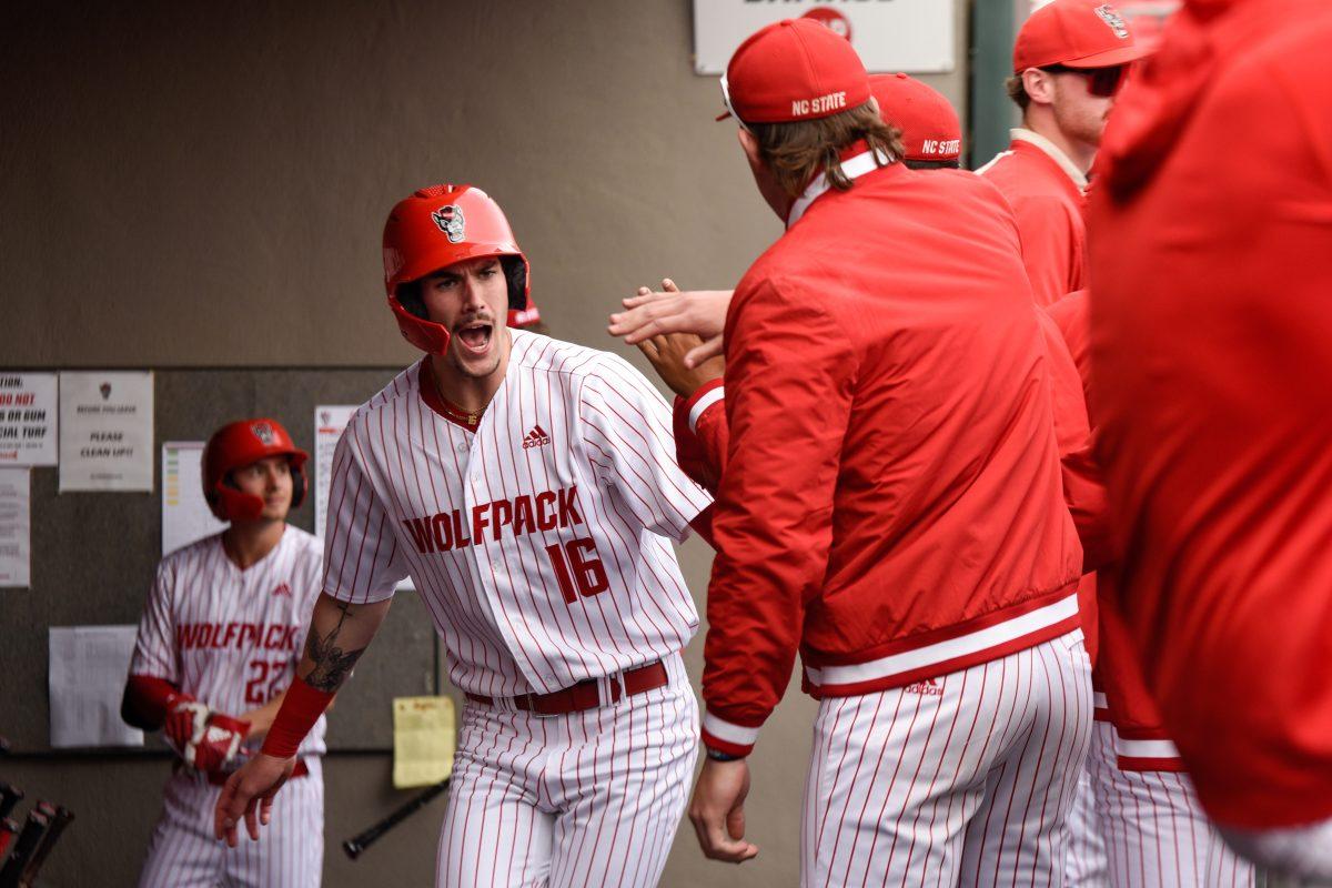 Sophomore outfielder Eli Serrano III shouts while high-fiving teammates during the game against Boston College in Doak Field at Dail Park on Friday, March 8, 2024. Serrano had two hits. The Wolfpack defeated the Eagles 5-4 (11).