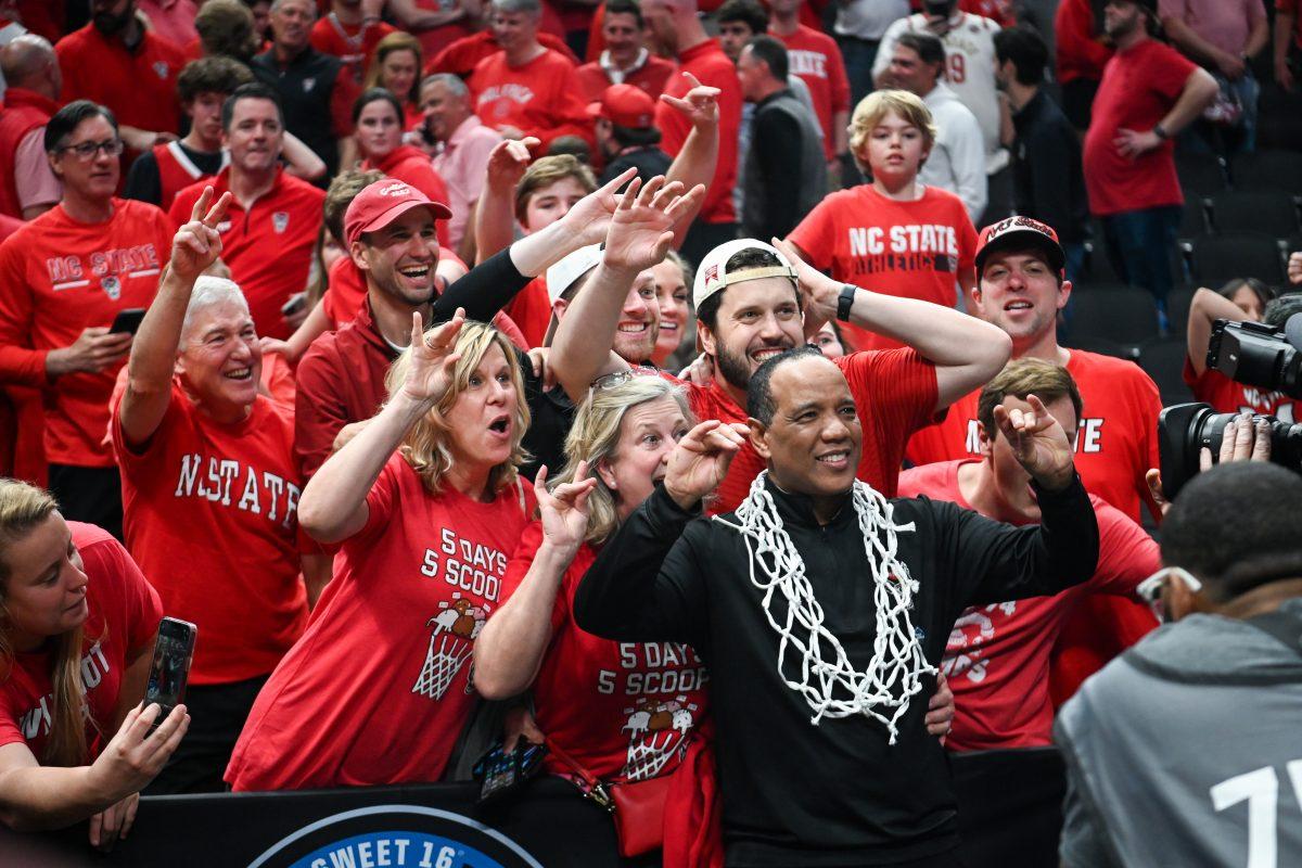 Head coach Kevin Keatts takes a photo with fans after winning the NCAA Tournament Elite 8 game against Duke at American Airlines Center in Dallas on Sunday, March 31, 2024. Burns led in scoring with 29 points. NC State beat Duke 76-64 to advance to the Final Four.
