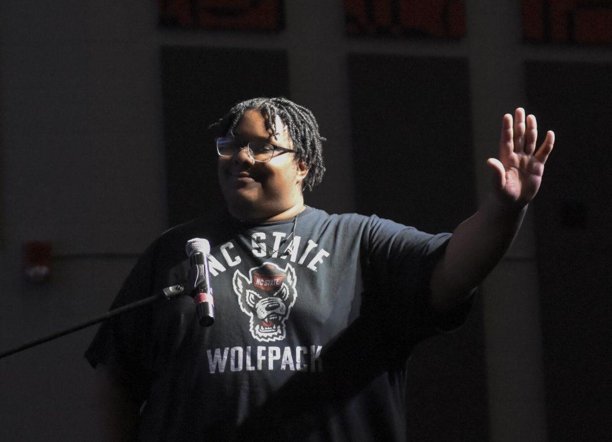 X raises their hand to silence their team while competing at the Packed Out Game Night event in Witherspoon Student Cinema on Wednesday, April 10, 2024. The students played "Black Jeopardy" hosted by the Black Student Board.