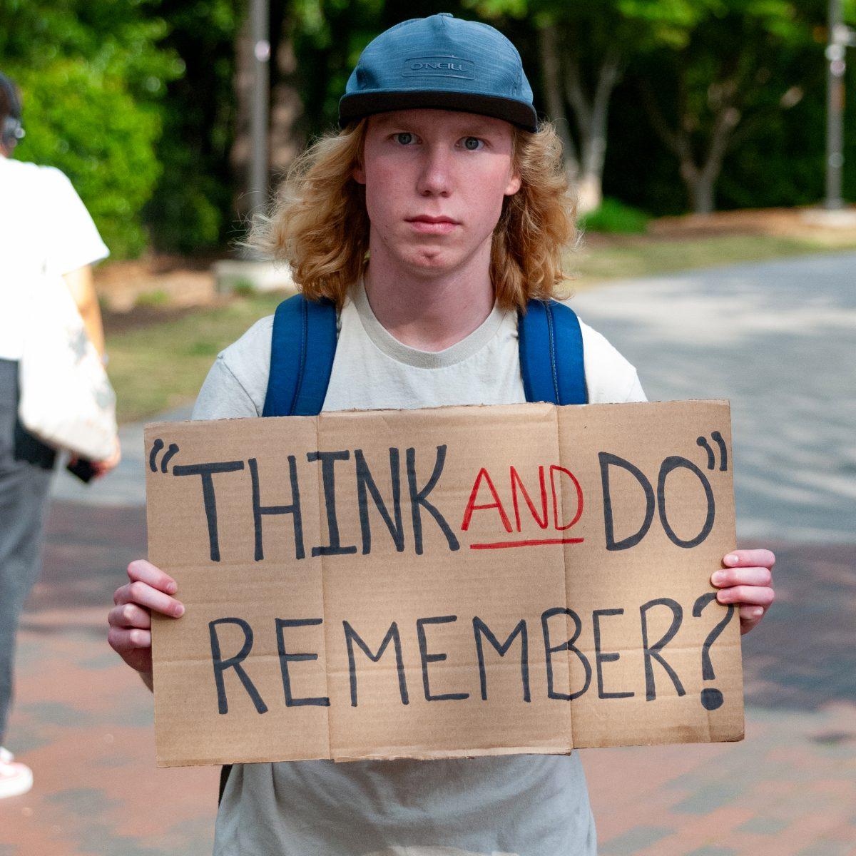 Oscar Cleaveland, a first-year in sustainable materials and technology, holds a sign during Earth Fair at Stafford Commons on Wednesday, April 14, 2023. The event sponsored by NC State&#8217;s University Sustainability Office&#160;offered education on sustainable practices.