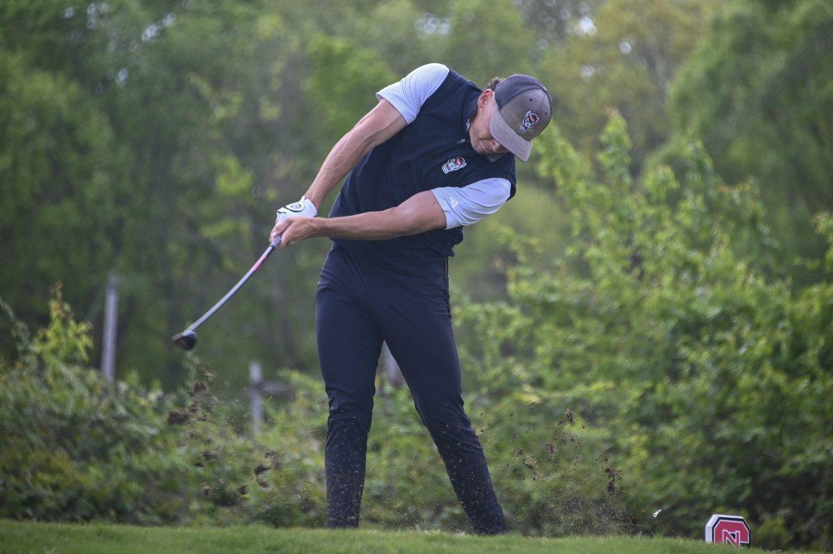 Redshirt junior Nick Matthews strikes the ball with his club during the Stitch Intercollegiate golf match on Lonnie Poole Golf Course on Friday, April 12, 2024. Matthews finished the first round in first with a score of 73.