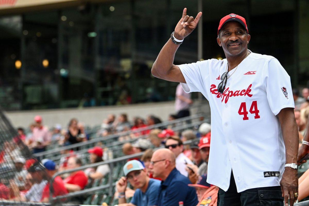 David Thompson, NC State men's basketball forward from 1972-75, holds up a "wolfie" while looking out into the crowd before the ACC Tournament game against Duke at Truist Field in Charlotte on Thursday, May 23, 2024. Thompson was a three time ACC Player of the Year and the first student athlete to have a statue on campus. NC State lost to Duke 8-1.
