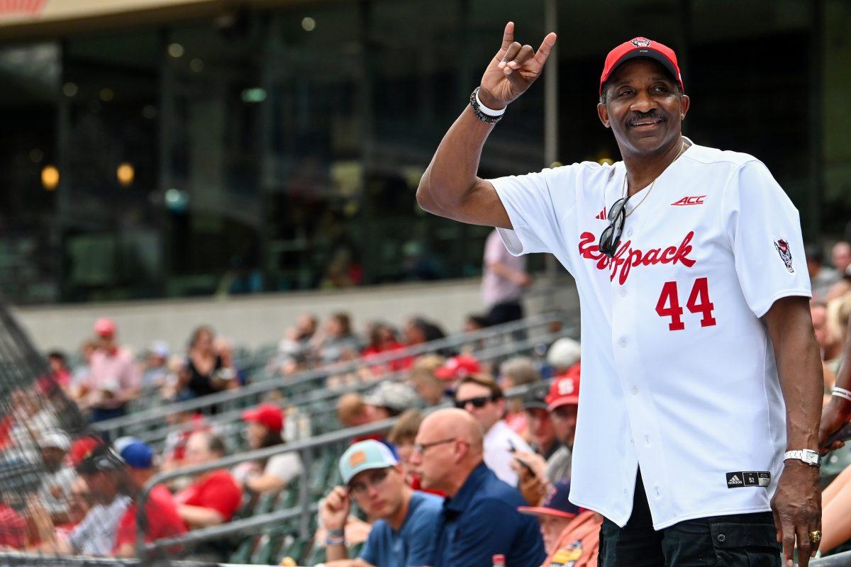 David Thompson, NC State men's basketball forward from 1972-75, holds up a "wolfie" while looking out into the crowd before the ACC Tournament game against Duke at Truist Field in Charlotte on Thursday, May 23, 2024. Thompson was a three time ACC Player of the Year and the first student athlete to have a statue on campus. NC State lost to Duke 8-1.
