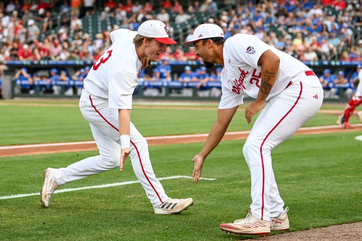 Junior infielder Brandon Butterworth low-fives sophomore pitcher Derrick Smith during the ACC Tournament game against Duke at Truist Field in Charlotte on Thursday, May 23, 2024. NC State lost to Duke 8-1.