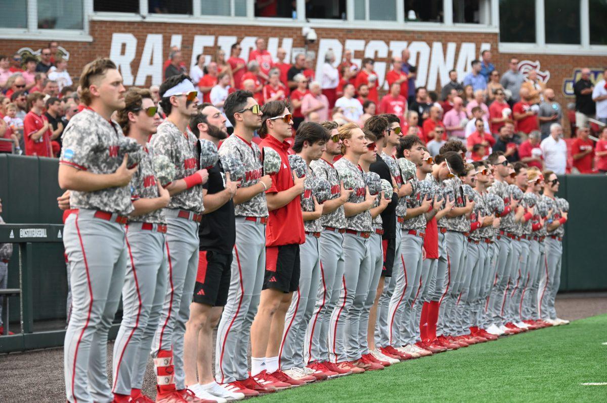 The NC State baseball team lines up for the national anthem before the Wolfpack's game against the James Madison Dukes in the NCAA Raleigh Regional final on Doak Field at Dail Park on Sunday, June 2, 2024. The Wolfpack beat the Dukes 5-3 to advance to the super regional round in Athens, Georgia.