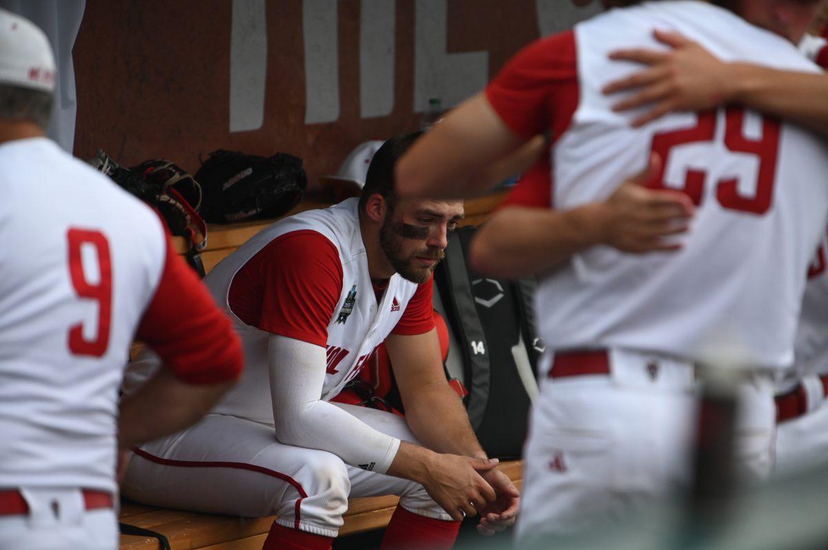 Junior catcher Jacob Cozart sits down in the dugout after the Wolfpack's Men's College World Series game against the Flordia Gators on Charles Schwab Field in Omaha, Nebraska on Monday, June 17, 2024. The Gators defeated the Wolfpack 5-4.