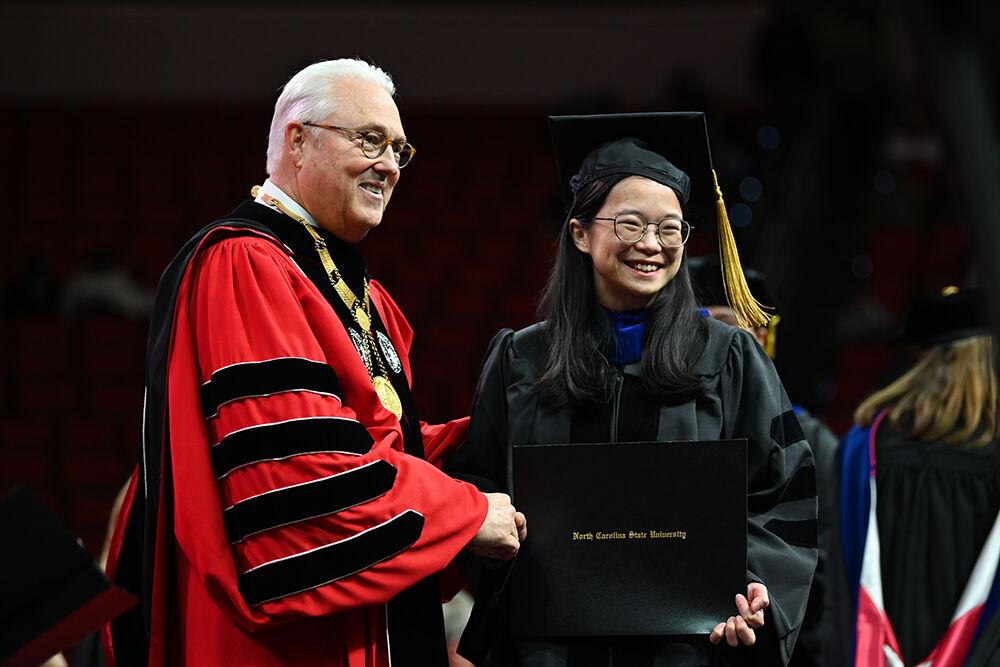 Chancellor Randy Woodson congratulates and shakes hands with Tzu-Yu Chen, a doctoral student in chemistry, during the Fall Commencement Ceremony in PNC Arena on Saturday, Dec. 16, 2023. There were 3,282 graduates and 3,411 degrees were conferred during the ceremony.