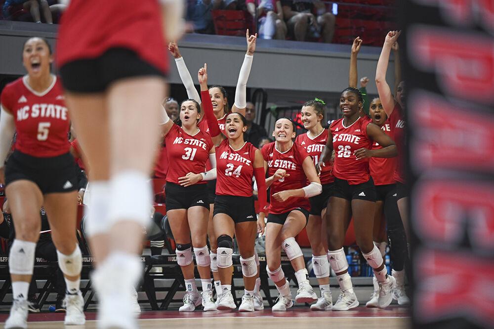 The NC State Volleyball team celebrates winning the second set during the match against Louisville in Reynolds Coliseum on Sunday, Oct. 1, 2023. NC State beat Louisvile 3-1.