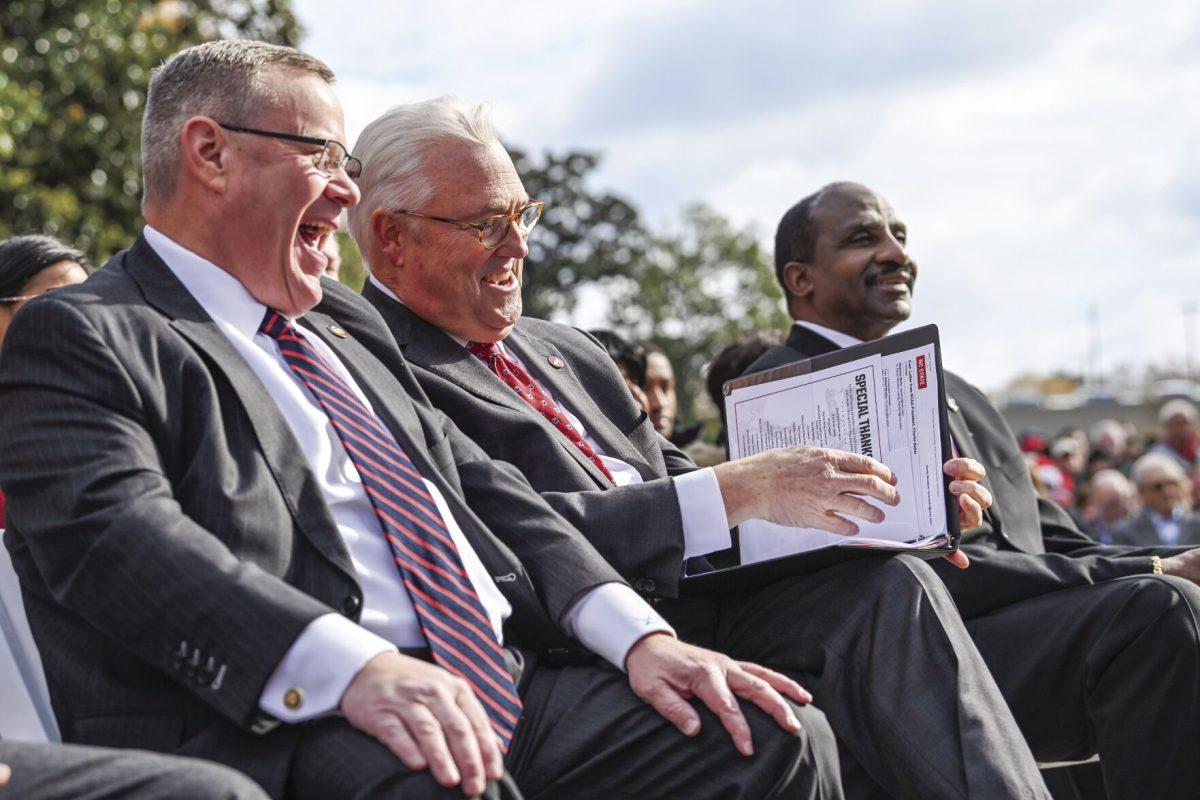 North Carolina House Speaker Tim Moore, Chancellor Randy Woodson and former NC State forward David Thompson laugh during the statue unveiling event outside of Reynolds Coliseum on Wednesday, Dec. 6, 2023. Thompson is the first student-athlete to have a statue on campus.