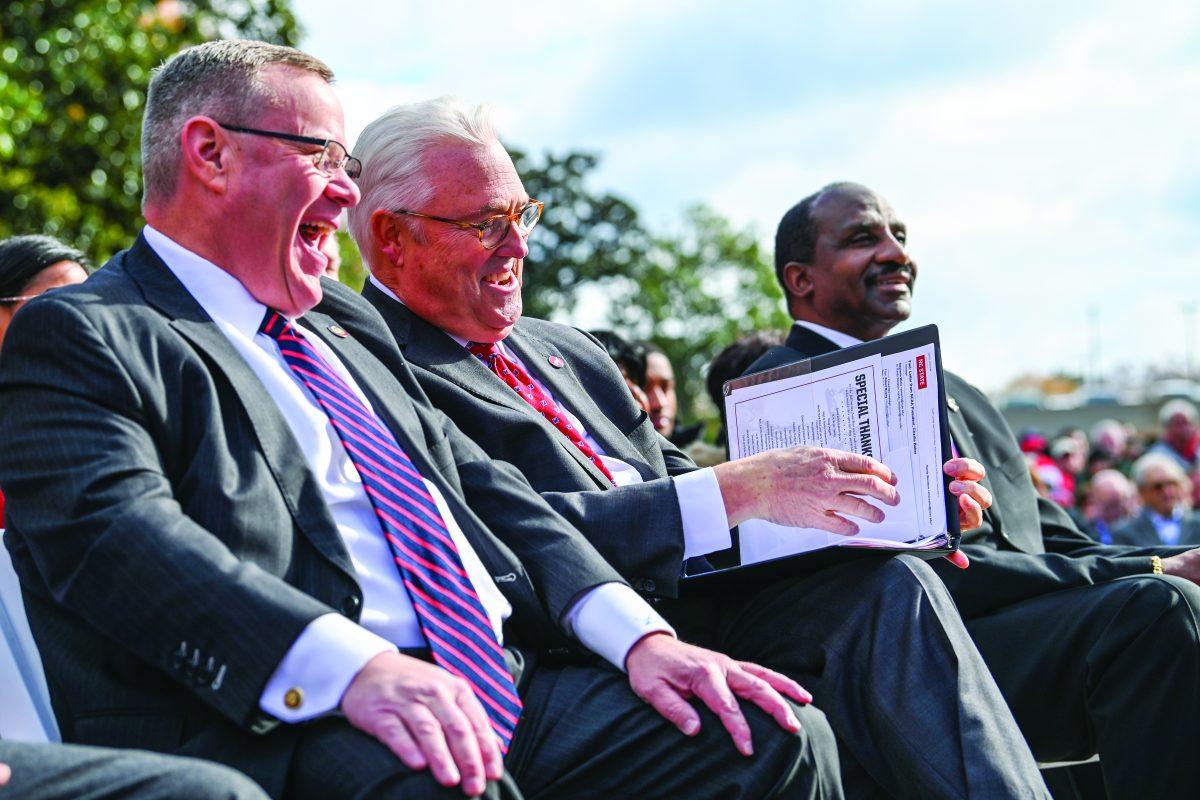 North Carolina House Speaker Tim Moore, Chancellor Randy Woodson and former NC State forward David Thompson laugh during the statue unveiling event outside of Reynolds Coliseum on Wednesday, Dec. 6, 2023. Thompson is the first student-athlete to have a statue on campus.