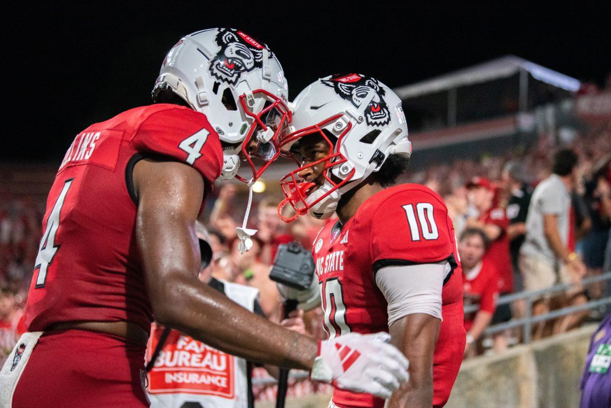 Redshirt junior wide receiver Dacari Collins and sophomore wide receiver KC Concepcion bump helmets after.a touchdown during the game against Western Carolina at Carter-Finley Stadium on Thursday, Aug. 29, 2024. The Wolfpack defeated the Catamounts 38-21.