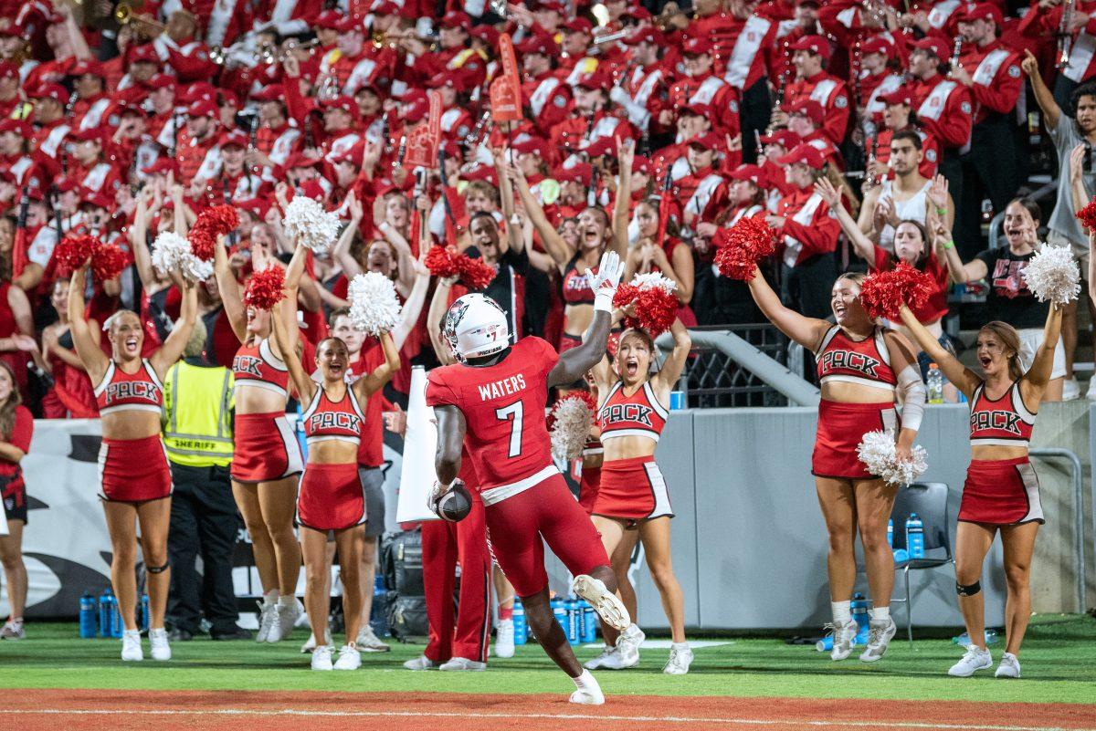 Graduate running back Jordan Waters waves to the crowd and high-fives cheerleaders after scoring a touchdown during the game against Western Carolina at Carter-Finley Stadium on Thursday, Aug. 29, 2024. Waters ran for two touchdowns. The Wolfpack defeated the Catamounts 38-21.