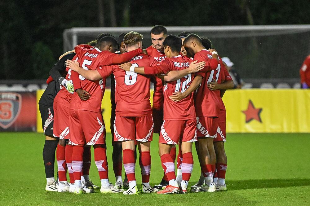 Members of the men's soccer team huddle up before the match against High Point at Dail Soccer Field on Tuesday, Oct. 17, 2023. The Wolfpack tied the match with the Panthers 0-0.