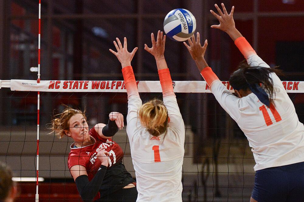 Junior opposite hitter Amanda Rice spikes the ball past two blockers during the match against Syracuse in Reynolds Coliseum on Sunday, Nov. 5, 2023. Rice made 10 kills. The Wolfpack defeated the Orange 3-0.