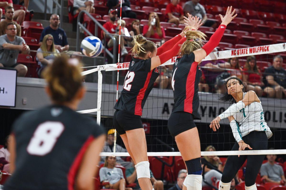 Junior outside hitter Courtney Bryant and junior middle blocker Sophie Groom attempt to block their opponents hit during the game against Coastal Carolina in Reynolds Coliseum on Sunday, Sept. 22, 2024. The Wolfpack lost to the Chanticleers 3-2.