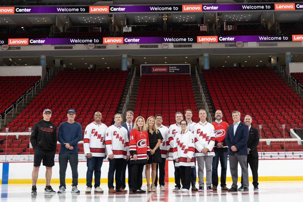 Carolina Hurricanes head coach Rod Brind'Amour and Tom Dundon Lenovo executives and pose on the ice at the Lenovo Center unveiling on Thursday, Sept. 19, 2024. Lenovo&#8217;s naming rights agreement runs for 10 years throughout the 2033-2034 NHL season.
