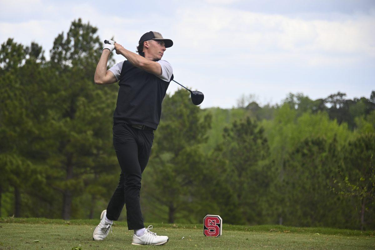 Redshirt junior Nick Matthews watches the ball after hitting it during the Stitch Intercollegiate golf match on Lonnie Poole Golf Course on Friday, April 12, 2024. Matthews finished the first round in first with a score of 73.