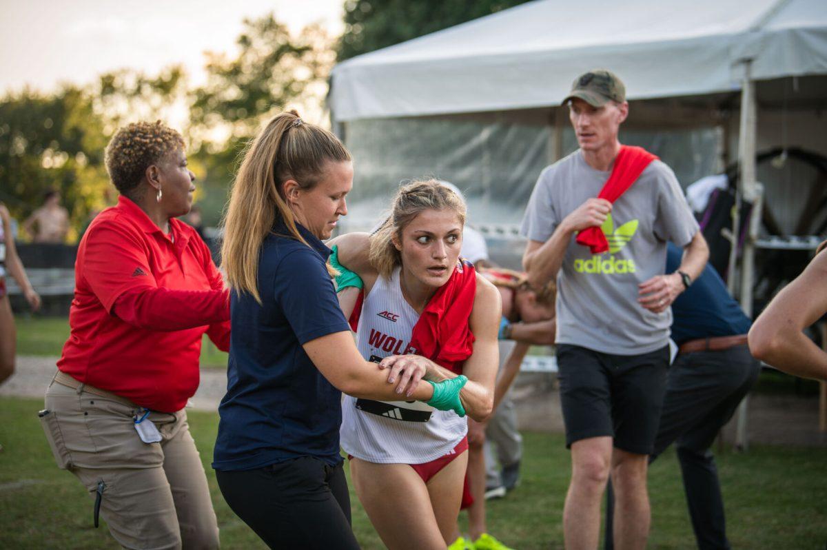 Race staff support freshman Kate Putman during the Adidas XC Challenge at WakeMed Soccer Park on Friday, Sept. 20, 2024. Putman finished with a time of 17:04.3. The NC State women's team finished in first place with a total of 34 points.
