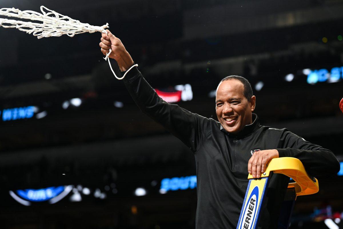 Head coach Kevin Keatts waves the net around after winning the NCAA Tournament Elite 8 game against Duke at American Airlines Center in Dallas on Sunday, March 31, 2024. Burns led in scoring with 29 points. NC State beat Duke 76-64 to advance to the Final Four.