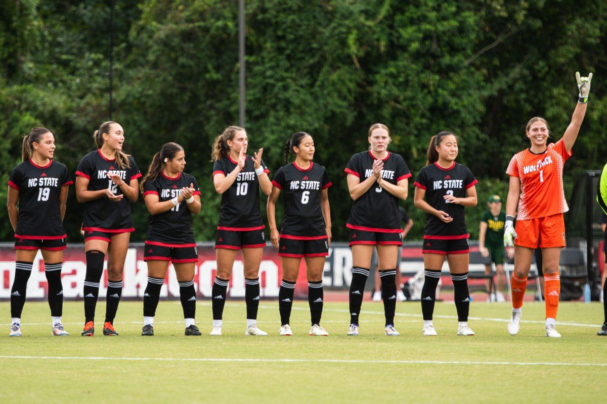 Junior goalkeeper Olivia Pratapas raises a wolfie while her teammates clap before the match against William &amp; Mary on Thursday, Sept. 12, 2024 at Dail Soccer Field. Pratapas had three saves during the match. NC State lost 1-0.