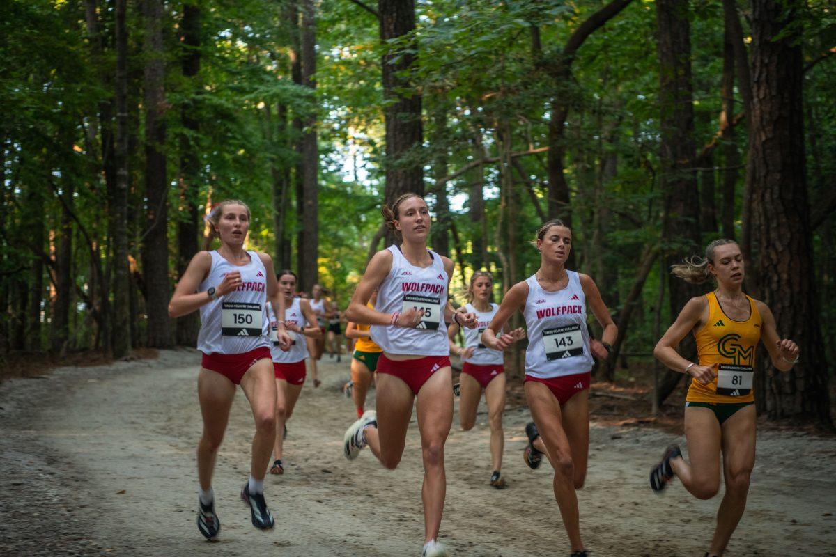 The trio of senior Fiona Smith (left), junior Grace Hartman (middle) and junior Hannah Gapes (right) run through the woods during the Adidas XC Challenge at WakeMed Soccer Park on Friday, Sept. 20, 2024. Smith finished sixth with 16:53.8, Hartman in fourth with 16:25.9 and Gapes in fifth with 16:26.5.The NC State women's team finished in first place with a total of 34 points.