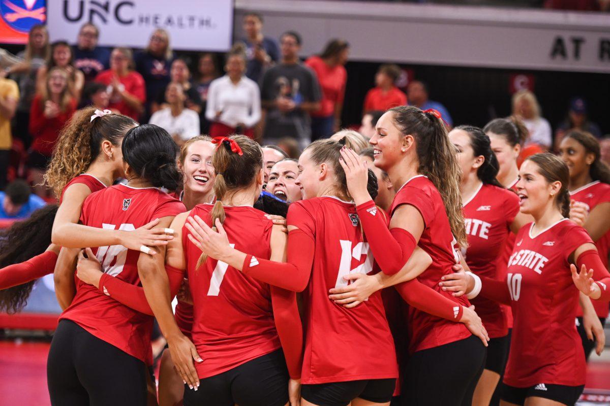 The NC State women's volleyball team celebrates their win against UVA following their home game at Reynolds Coliseum on Sunday, Sept. 29, 2024. The NC State Wolfpack went on to beat the UVA Cavaliers 3-1.