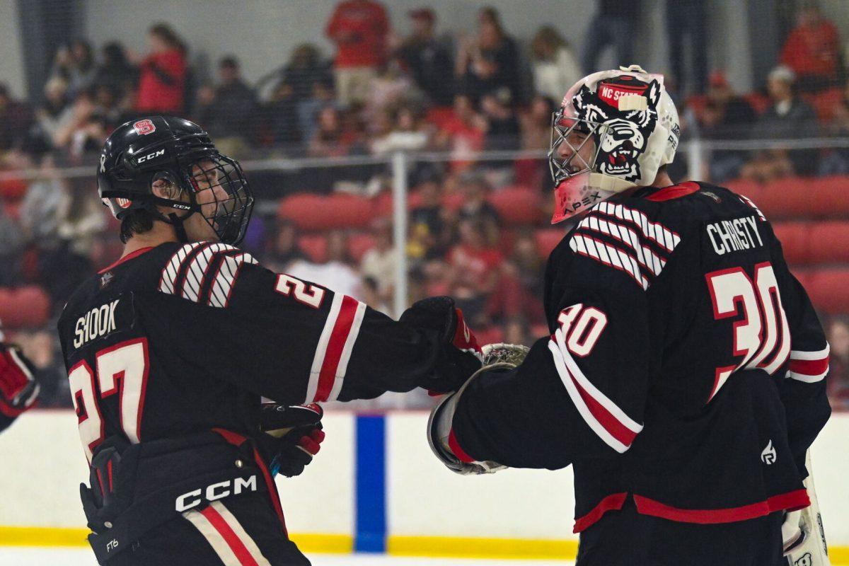 Sophomore forward Nick Shook (left) celebrates the end of the game with Freshman goalie Dillon Christy (left) after the game against High Point University at Invisalign Arena on Friday, Sept. 6, 2024. NC State won 8-2.
