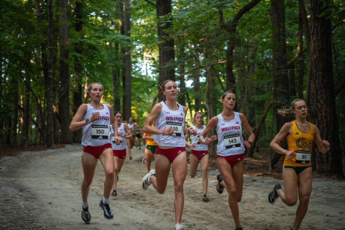 The trio of senior Fiona Smith (left), junior Grace Hartman (middle) and junior Hannah Gapes (right) run through the woods during the Adidas XC Challenge at WakeMed Soccer Park on Friday, Sept. 20, 2024. Smith finished sixth with 16:53.8, Hartman in fourth with 16:25.9 and Gapes in fifth with 16:26.5.The NC State women's team finished in first place with a total of 34 points.